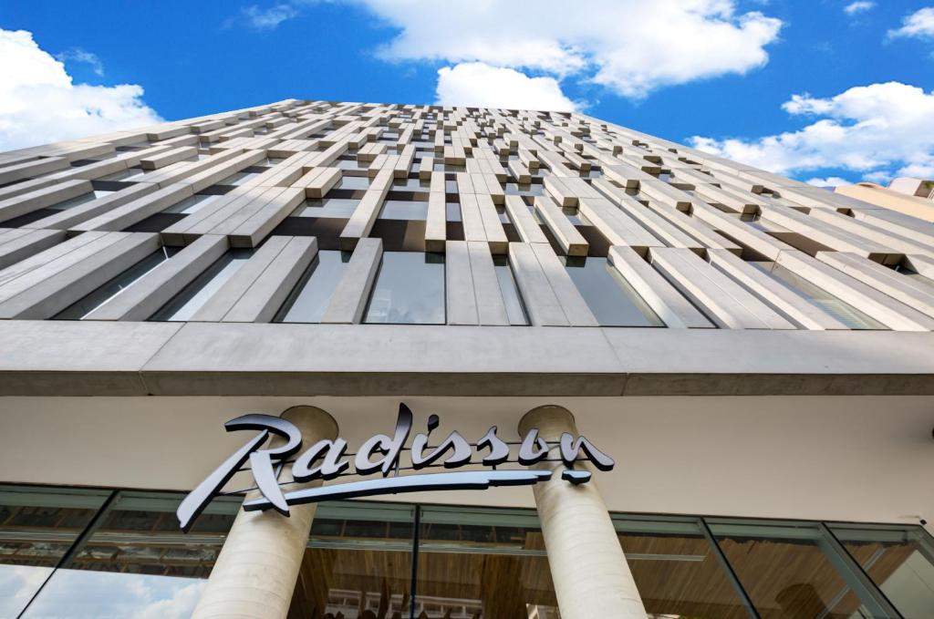 a tall building with a sign in front of it at Radisson Pinheiros in Sao Paulo