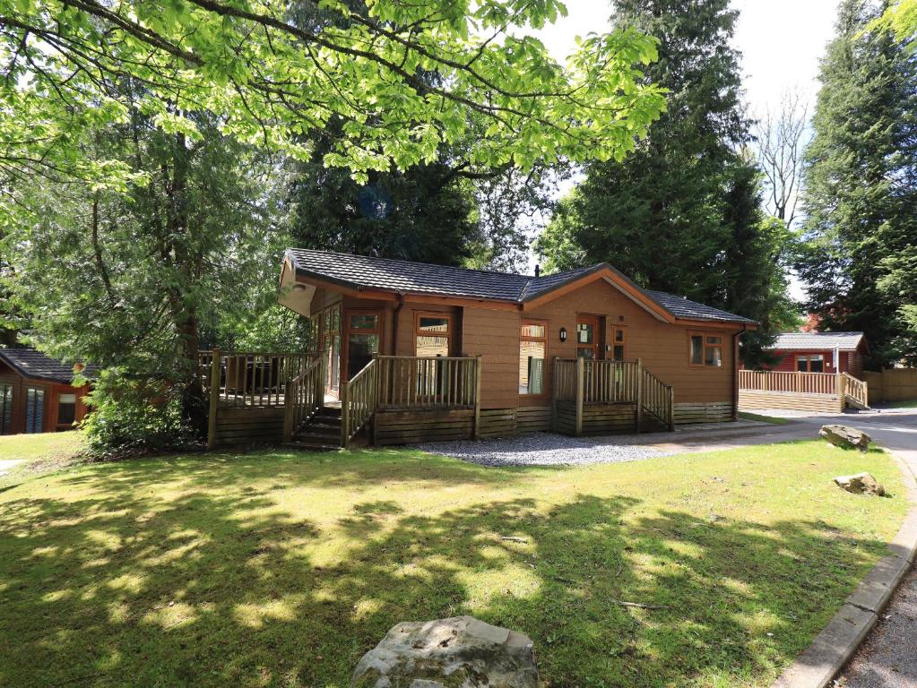 a cabin in a park with a yard at Forest Pines Lodge in Bowness-on-Windermere