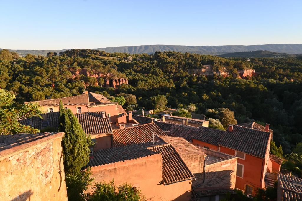 uma vista para uma aldeia nas colinas em Maison Porte Heureuse em Roussillon