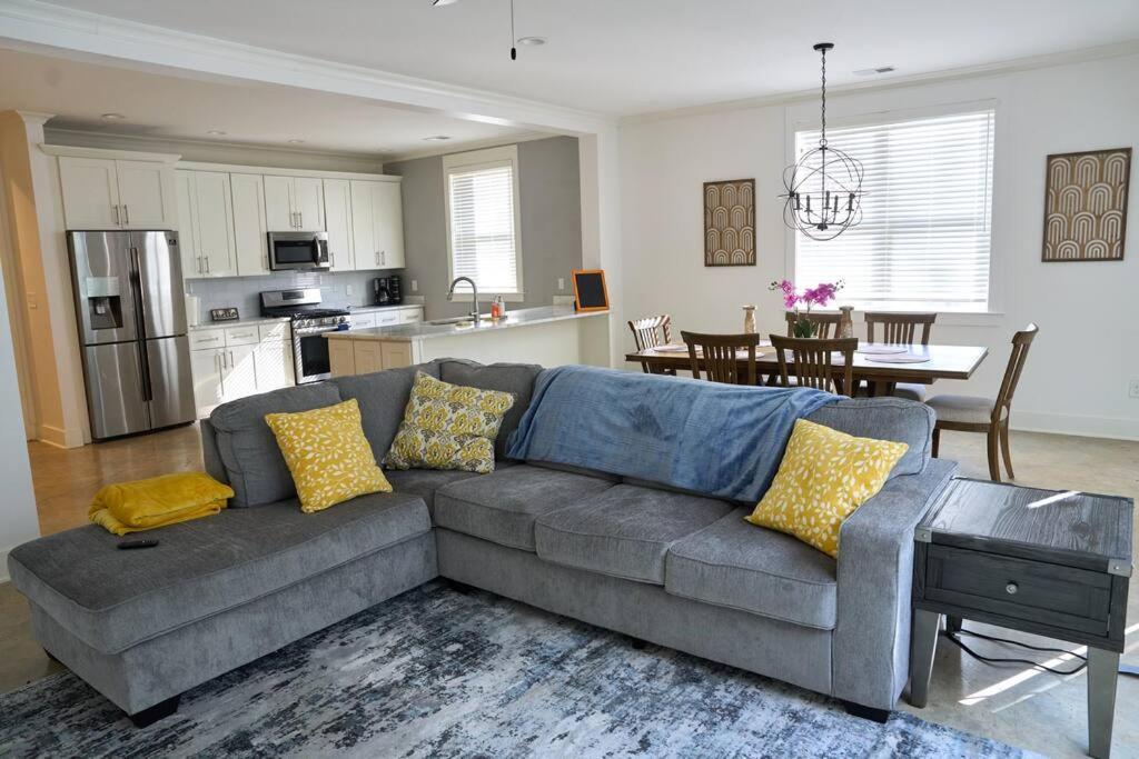 uma sala de estar com um sofá e uma cozinha em Modern Midtown home with 3 king beds em Memphis