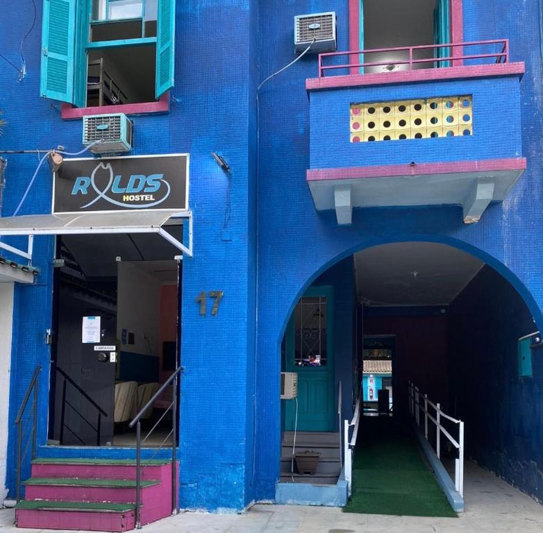 niebieski budynek z drzwiami i balkonem w obiekcie Rolds Hostel w mieście Santos