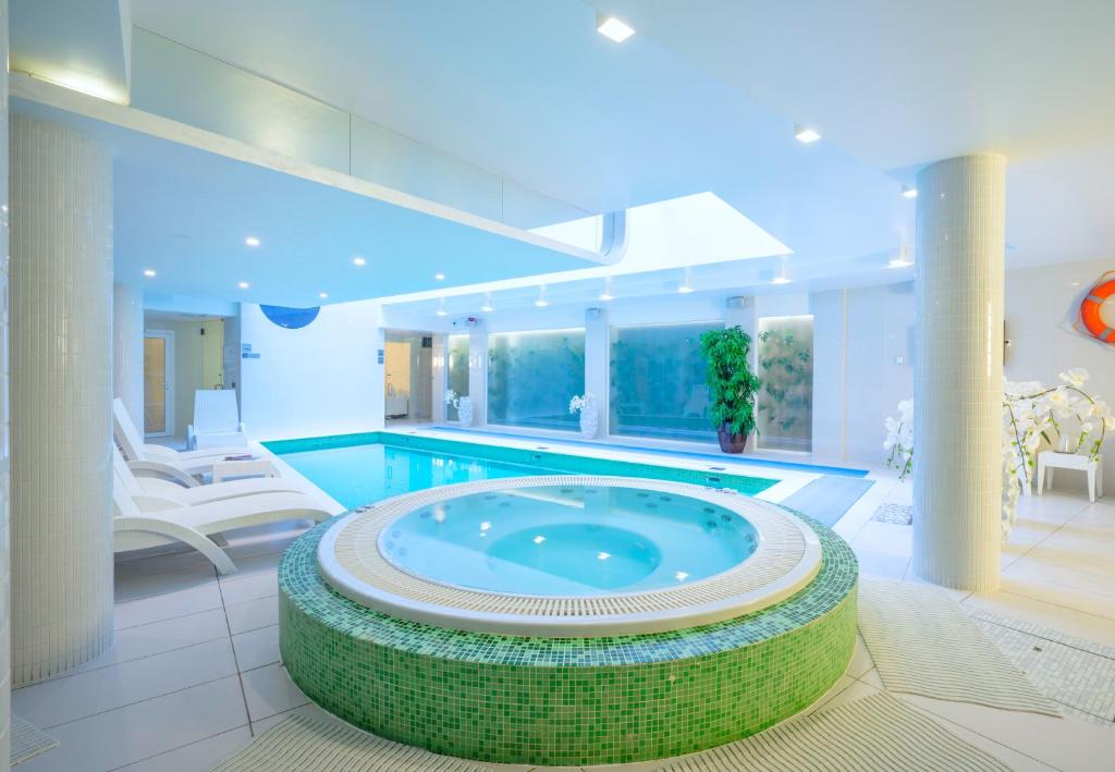 - une grande piscine dans une grande pièce avec piscine dans l'établissement Wellton Centrum Hotel & SPA, à Riga