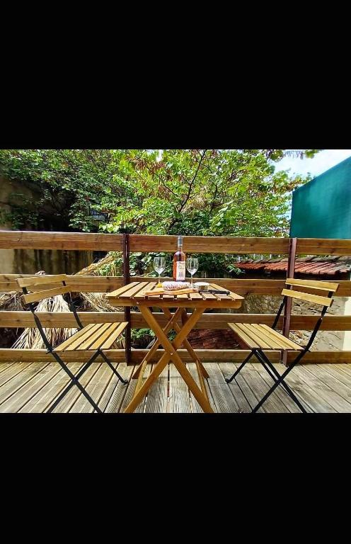 une table et des chaises en bois sur une terrasse en bois dans l'établissement La calme terrasse, à Hyères