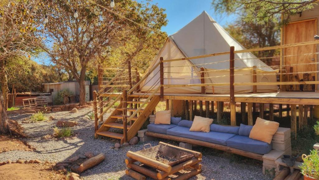 a living area with a blue couch and a tent at Glamping Dunas del sol in San Pedro de Atacama
