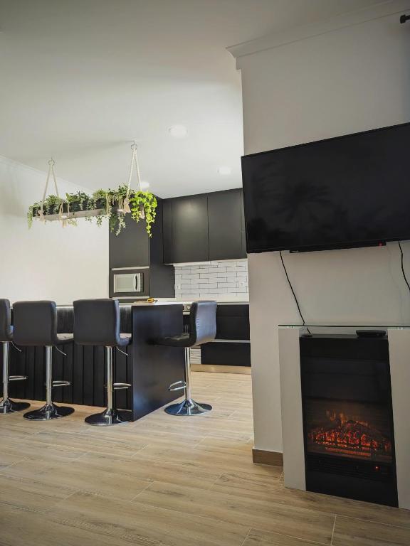 a room with a fireplace and a bar with stools at Wow space Peniche - 3 Bedrooms & 2 Bathrooms in Peniche