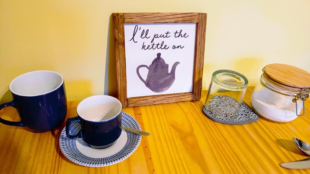 una mesa con dos tazas y una foto en ella en Bowtree House Bed and Breakfast en Grantham