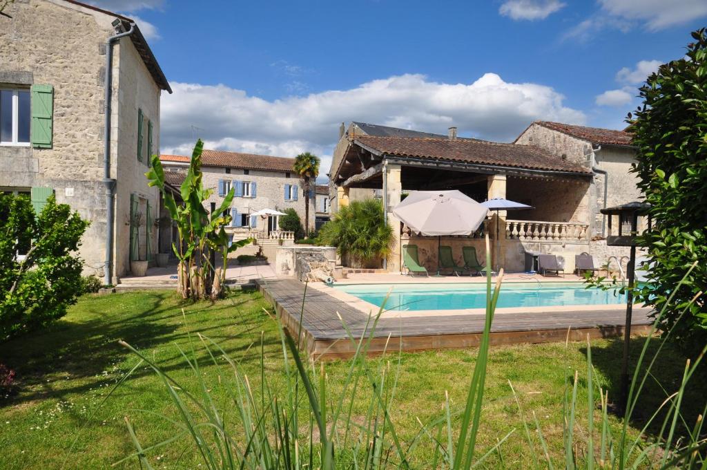 an external view of a house with a swimming pool at Le Hangar in Saint-Jean-dʼAngély