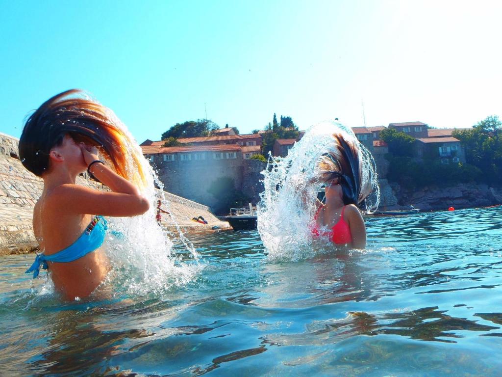 dwie młode dziewczyny bawiące się w wodzie w obiekcie Apartments Slavica Jovanovic w miejscowości Sveti Stefan