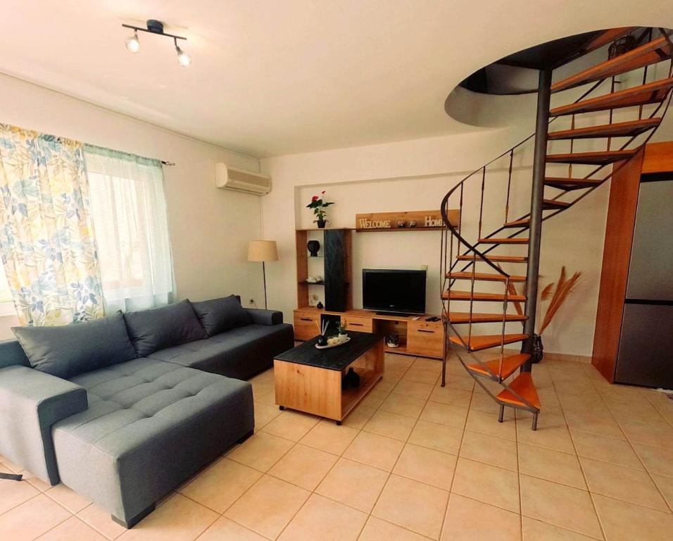 a living room with a couch and a spiral staircase at George Seaside House Makry Gialos in Makry Gialos