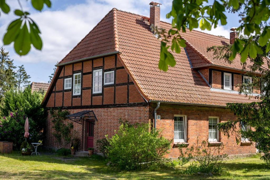 una antigua casa de ladrillo con techo marrón en Ferienwohnung 1 im Landhaus am Wildpark Boek, en Boek