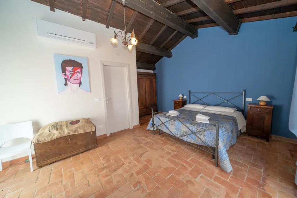 1 dormitorio con cama y pared azul en Villa Borgo degli Artisti Exclusive, en Aulla