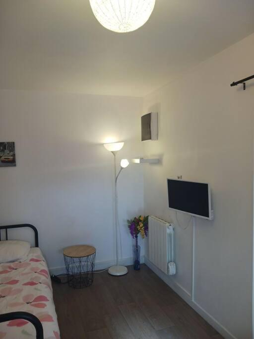 Cette chambre comprend un lit et une télévision murale. dans l'établissement studio cool, à Bonsecours