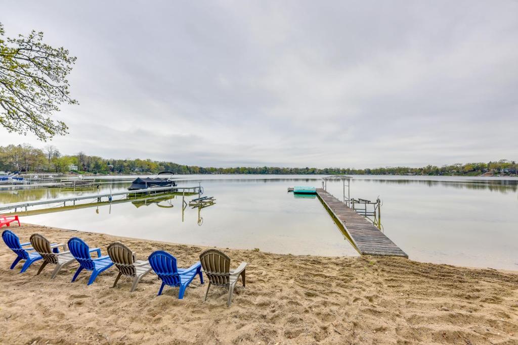 a group of chairs sitting on a beach next to a dock at Lakefront Burlington Vacation Rental Dock and Beach in Twin Lakes