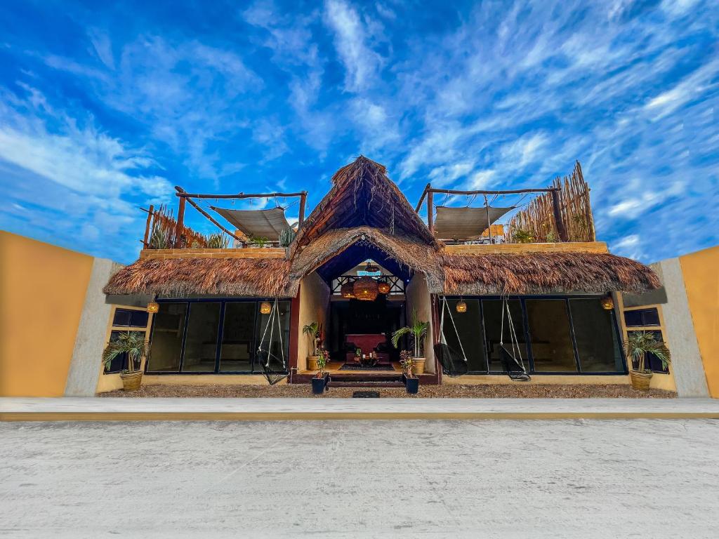 a building with a straw roof on top of it at Hotel Bohonito Holbox in Holbox Island