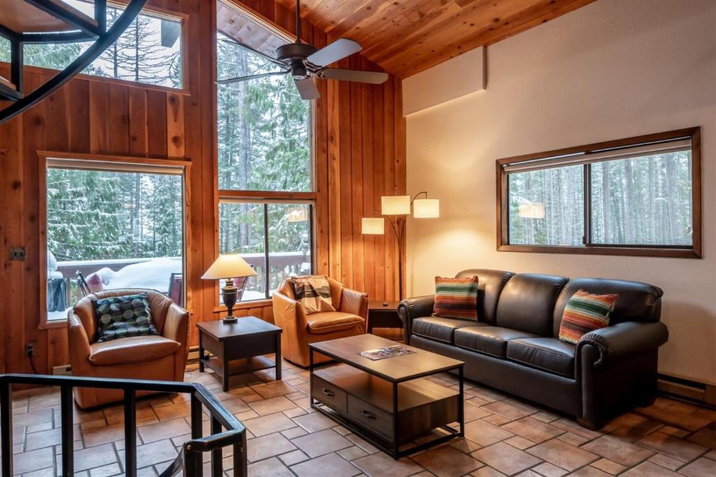 a living room with a leather couch and chairs at Escape To Ptarmigan Village 100 in Whitefish