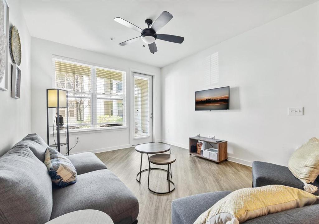 a living room with a couch and a ceiling fan at Luxurious 1 Bedroom Apartment Near Braves Stadium in Atlanta