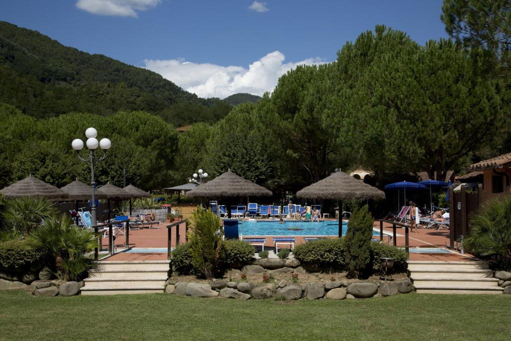 a swimming pool with umbrellas and a resort at Villaggio Albergo San Lorenzo e Santa Caterina in Pescia
