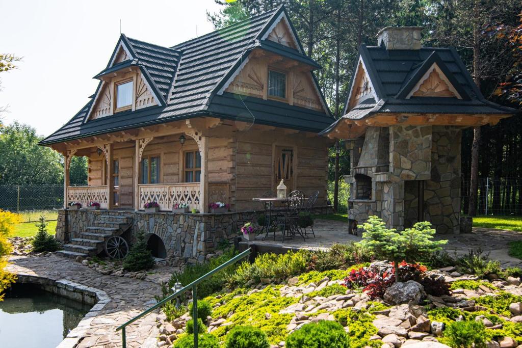 uma cabana de madeira com um lago no quintal em CamPetrus- Dom nad wodami Bystrego em Stare Bystre