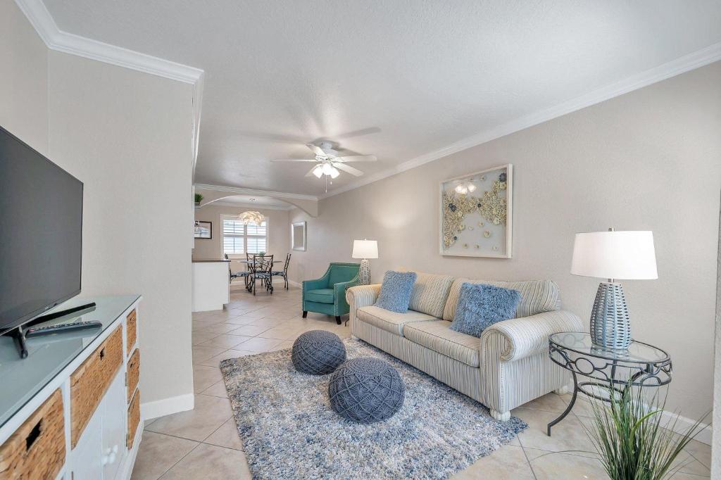 a living room with a couch and a tv at 2 Bed-1 Bath With Sunroom, Private Pool And Beach Access! in Clearwater Beach