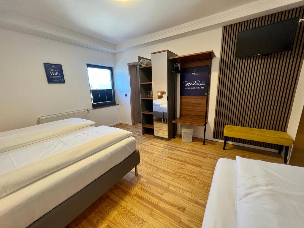 Postel nebo postele na pokoji v ubytování JUNIPRO Hotel Schinderhannes