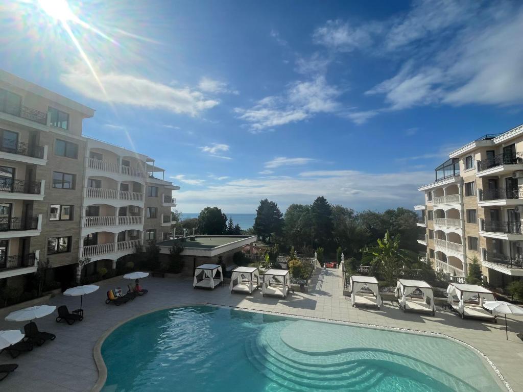 a swimming pool with lounge chairs and a building at South Beach Apartment at Valencia Gardens in Nesebar