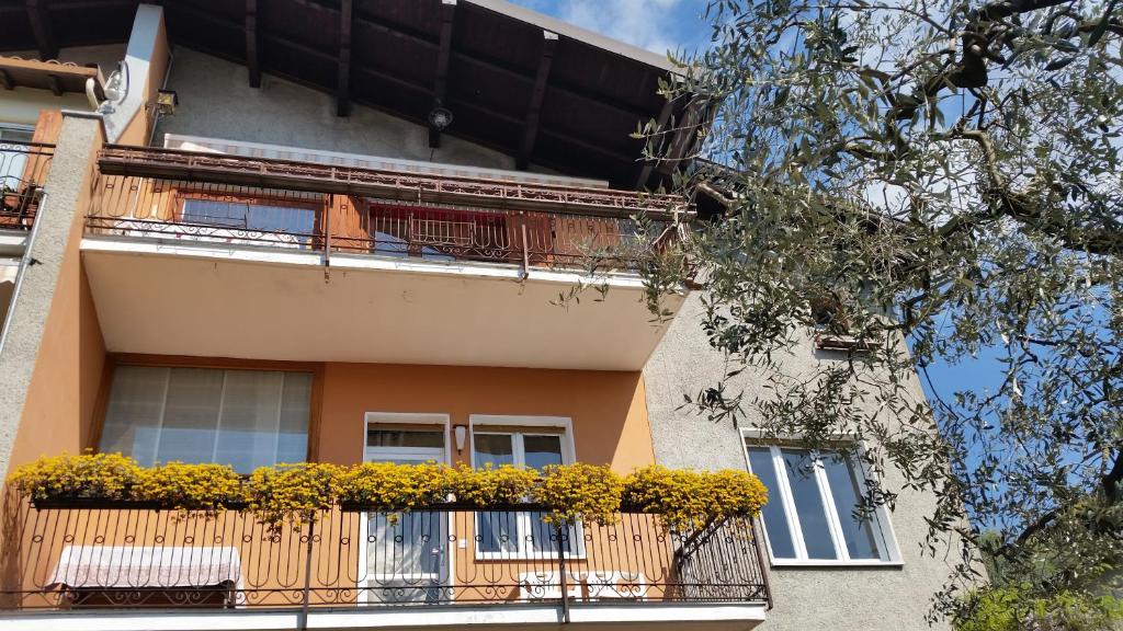 a building with a balcony with flowers on it at Apartment Iseo Lake in Sale Marasino