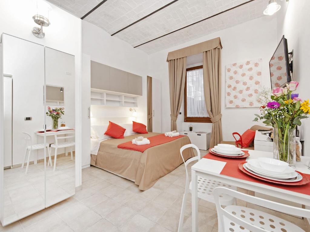 ローマにあるCoral flat Colosseoのベッド、テーブル、椅子が備わるホテルルームです。
