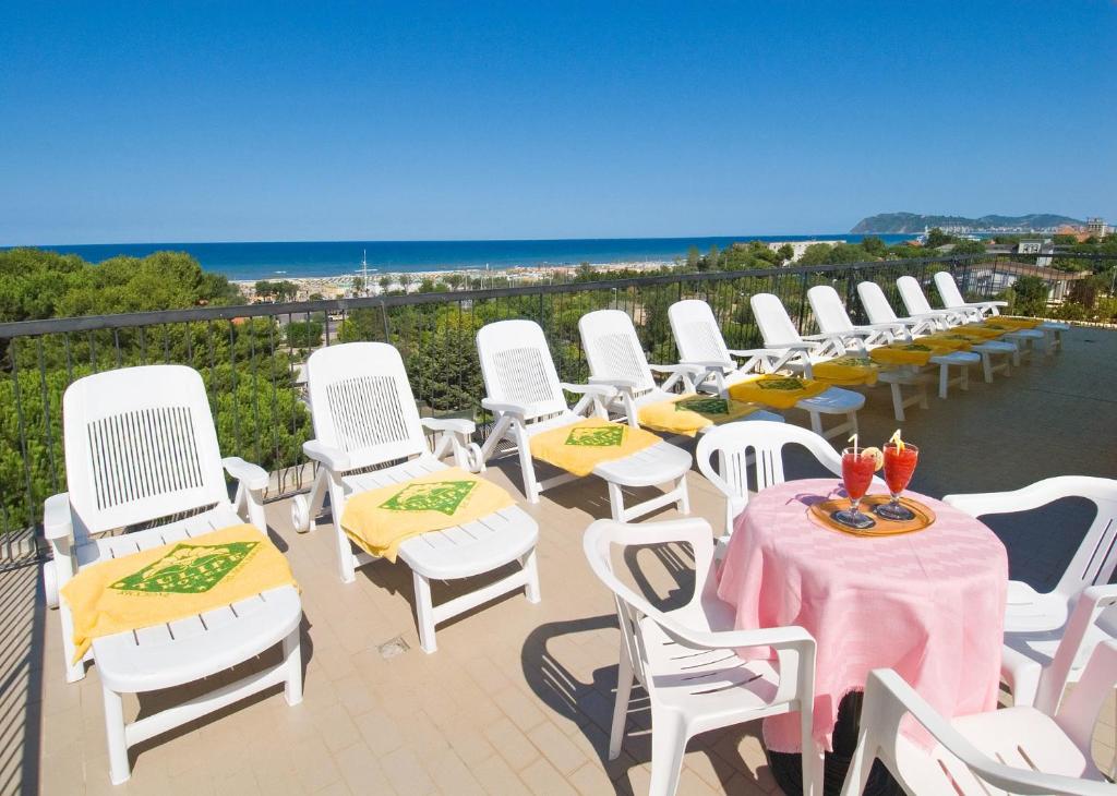 een rij witte stoelen en tafels op een patio bij Hotel Tulipe Nazionale in Riccione