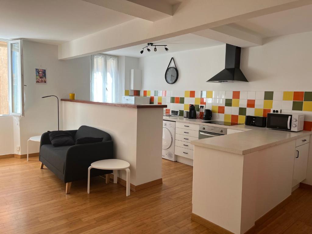 uma cozinha e sala de estar com um sofá e uma mesa em Appartement Hyères - Centre ville 'Parcours des Arts' 1 chambre 2 personnes - Patricia em Hyères