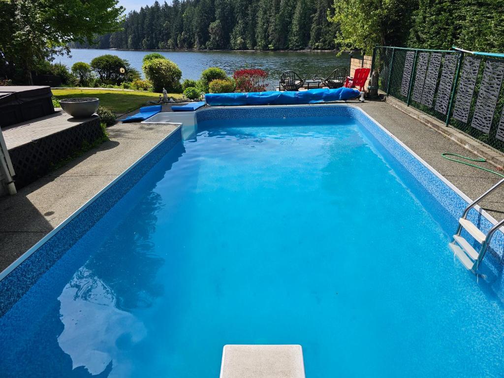 a large blue swimming pool with a view of a lake at luxury ocean dock pool villa in Ladysmith