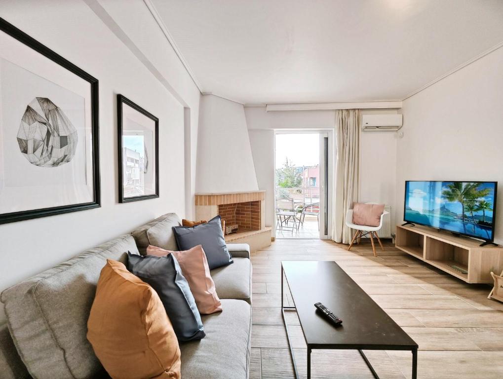 a living room with a couch and a tv at Kalipsous Apartments by Verde Apartments in Athens