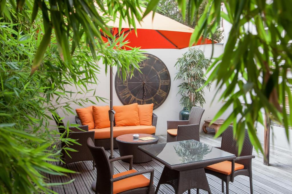 un patio esterno con un divano arancione e un tavolo di Best Western Plus Hotel Villa D'est a Strasburgo