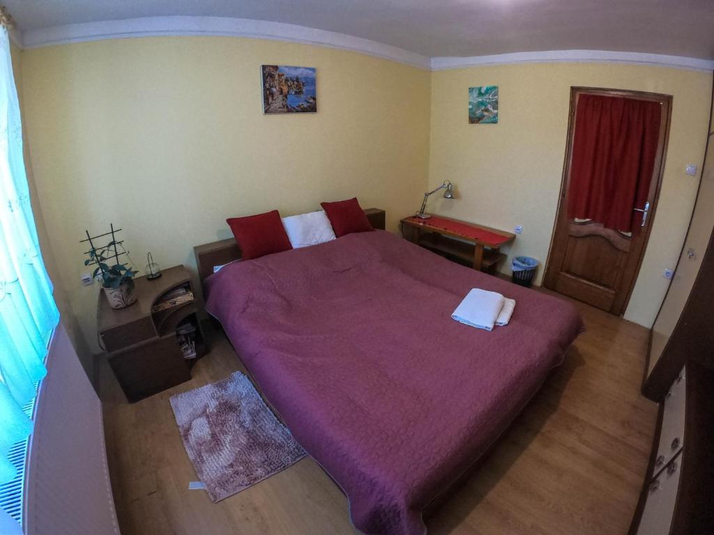 a bedroom with a large bed with a purple blanket at sobe MAŠA in Subotica