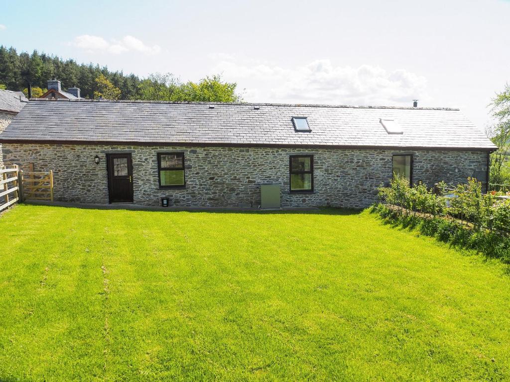 a stone house with a large lawn in front of it at Parlwr Godro - Uk41513 in Llanfair Clydogau