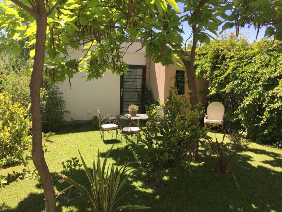 a garden with two chairs and a table in the yard at Stunning modern apartment in gated community in Ciudad Lujan de Cuyo