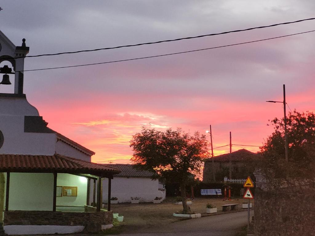 a sunset over a small town with a church at Hotel Restaurante el Fornon in Novellana