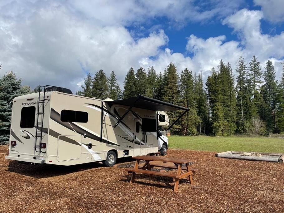 a camper parked in a field with a picnic table at Quiet Country Rimrock Retreat RV in Hayden