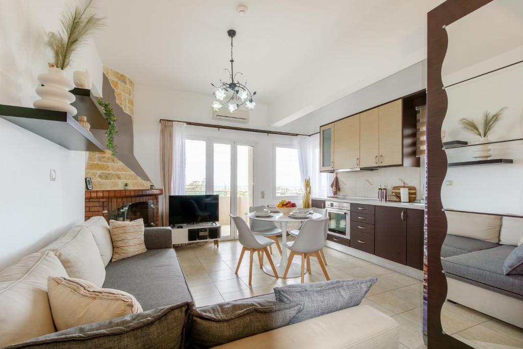 ヘルソニソスにあるΝΜΒ Anissaras Coastal Getawayのソファとテーブルのあるリビングルームとキッチン