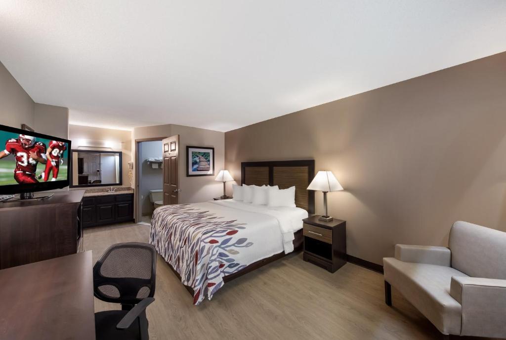 ジャスパーにあるRed Roof Inn Jasperのベッド1台、薄型テレビが備わるホテルルームです。