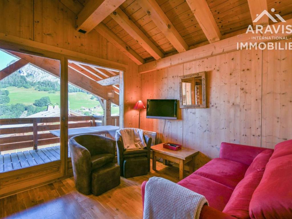 a living room with a purple couch and a tv at Appartement Le Grand-Bornand, 4 pièces, 6 personnes - FR-1-391-98 in Le Grand-Bornand