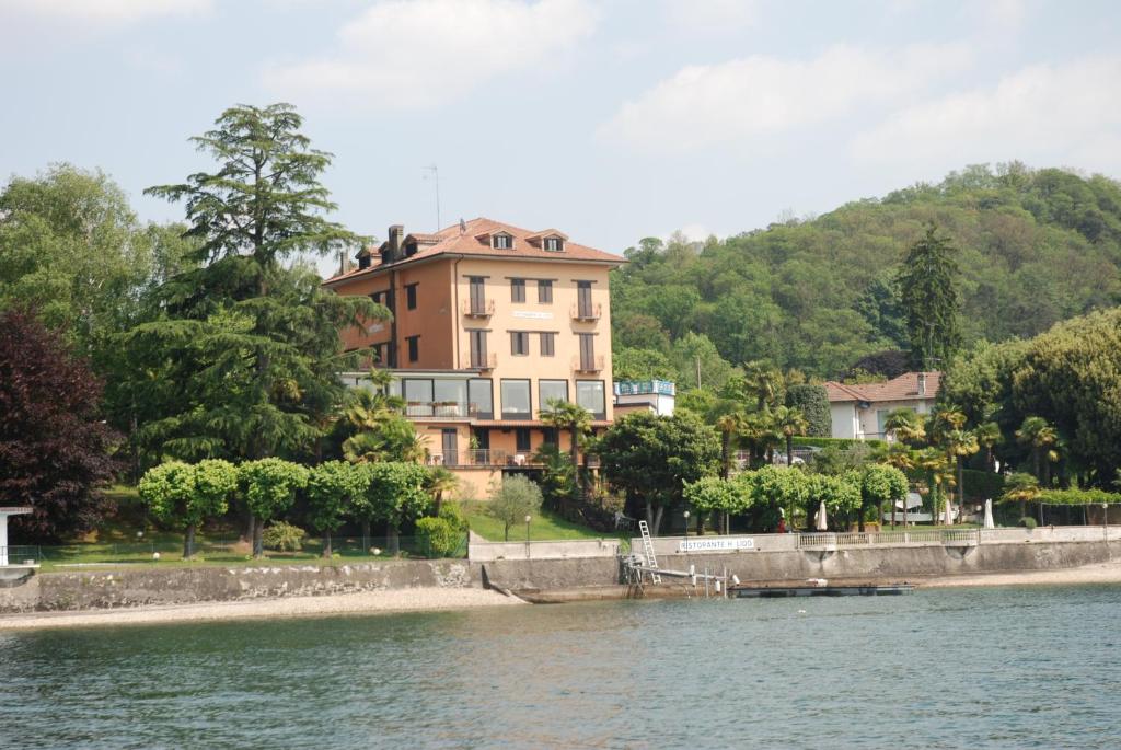 a large house on the side of a lake at Hotel Lido in Angera