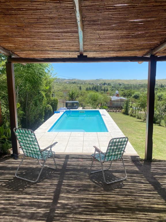 2 sillas sentadas en una terraza cerca de una piscina en Cabaña Las Calandrias in 