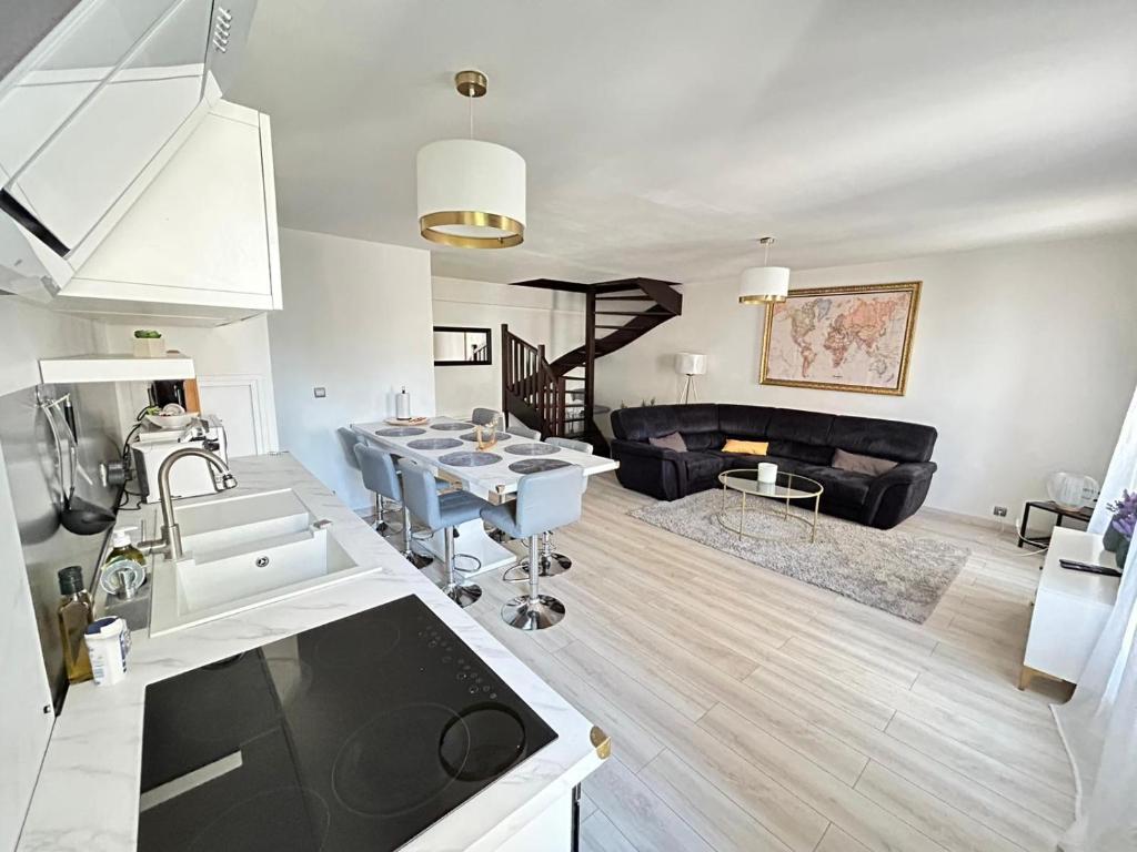 a kitchen and living room with a table and a couch at SPACIEUX DUPLEX PRES DES QUAIS DE SEINE LINGE MAISON FOURNI PARKING GRATUIT 4 CHAMBRES bienvenue à vous in Rouen