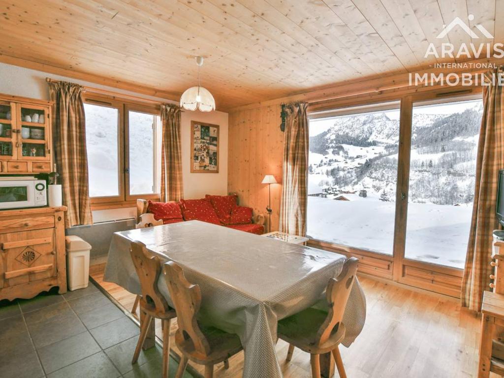 a living room with a table and a large window at Appartement Le Grand-Bornand, 3 pièces, 5 personnes - FR-1-391-132 in Le Grand-Bornand