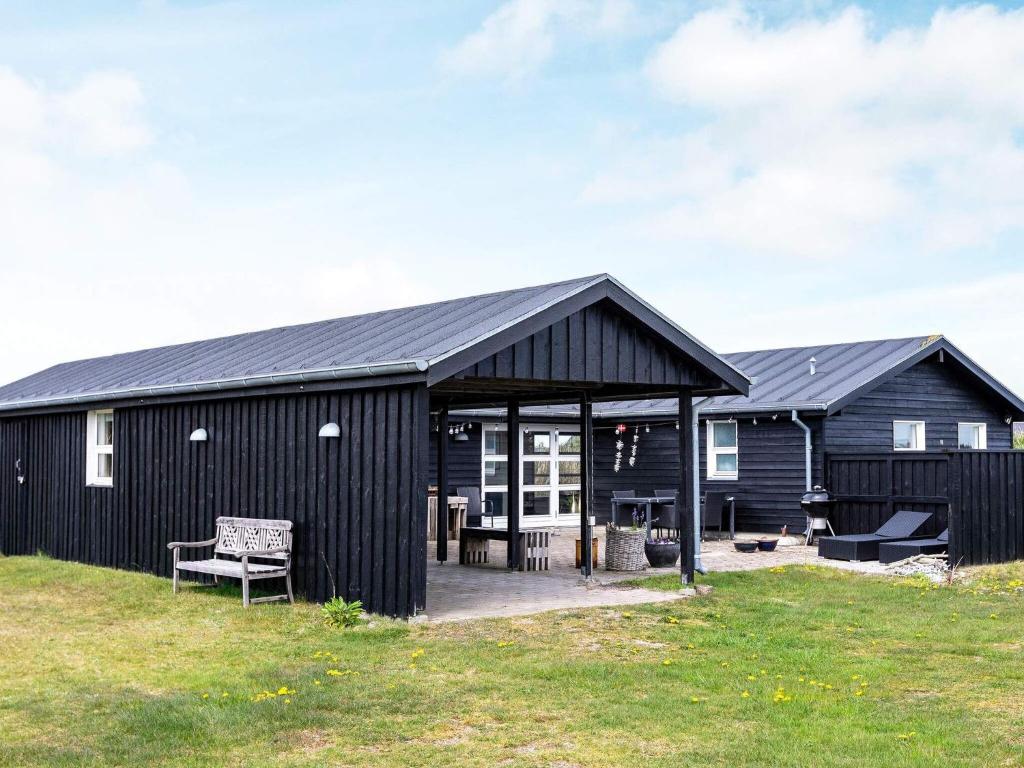 een zwart huis met een zwart dak bij Two-Bedroom Holiday home in Løkken 20 in Løkken