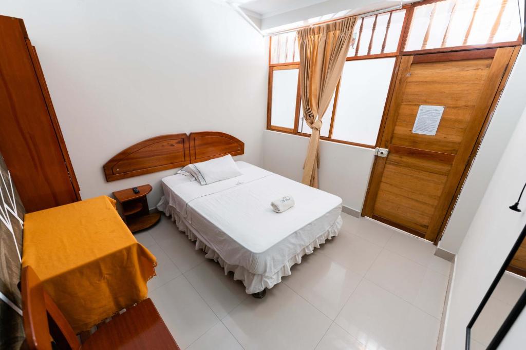 Habitación pequeña con cama y ventana en Eco Hostal La Cueva - Moyobamba, en Moyobamba