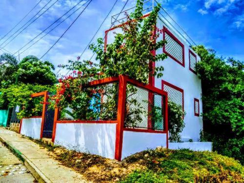 a white building with red trim next to a street at LAS HAMACAS, 2 minutes from the old town, we speak english!! in Cartagena de Indias