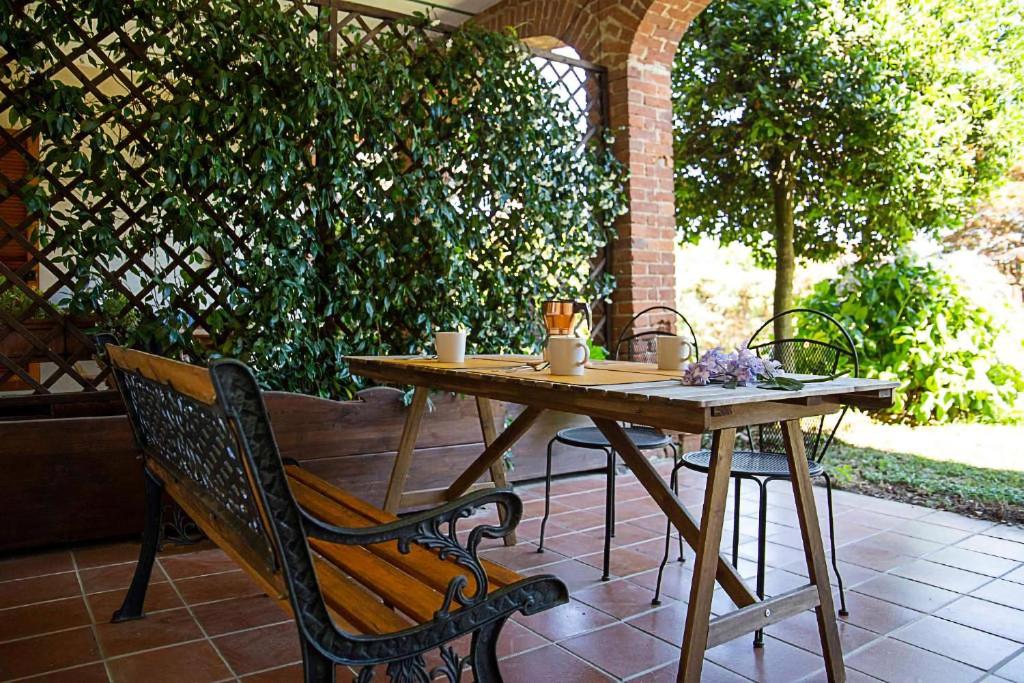 - une table et un banc en bois sur la terrasse dans l'établissement LE ORTENSIE - Holiday country house, à Pisano