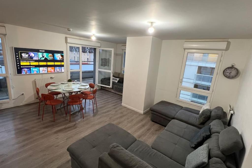 a living room with a couch and a table at Appartement standing proche Arena Paris La Défense in Nanterre