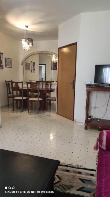 a living room with a table and a dining room at شقة من غرفتين نوم وصالة in Tangier